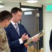 Noble Smith and Natalie Riedel present Cadet Squadron 9 with a flag flown in space