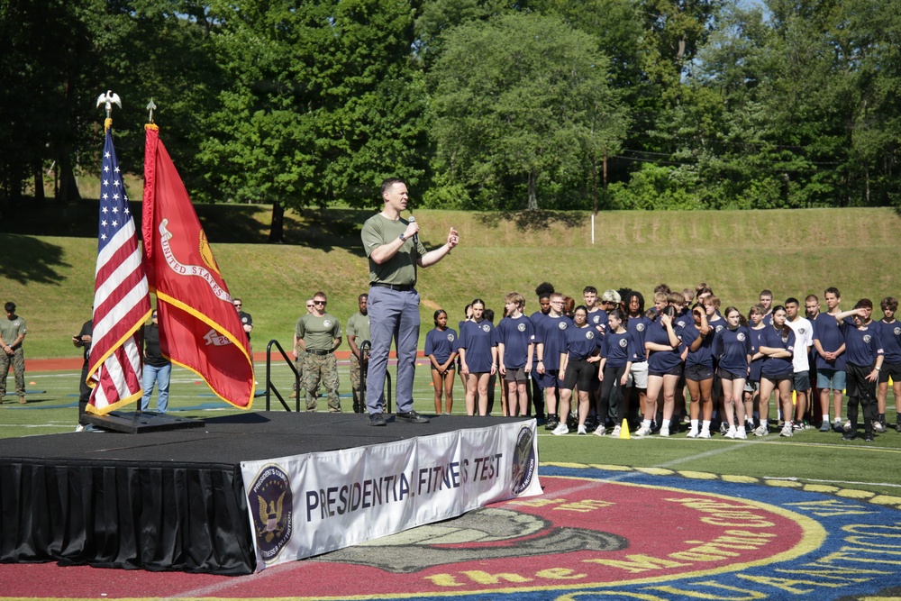 Mr. Tim Dill, assistant secretary of War for manpower and reserve affairs, addresses DoWEA students, parents, staff and Marines during the Presidential Physical Fitness Test