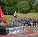Mr. Tim Dill, assistant secretary of War for manpower and reserve affairs, addresses DoWEA students, parents, staff and Marines during the Presidential Physical Fitness Test