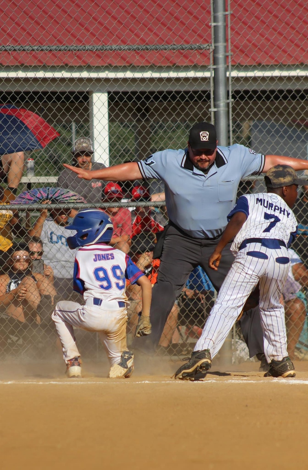 Umpire Signals Safe as Runner Slides Into Home Plate During Youth Baseball Game