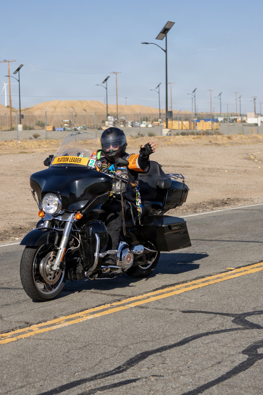 Platoon Leader Waves During Military Motorcycle Ride at Desert Installation
