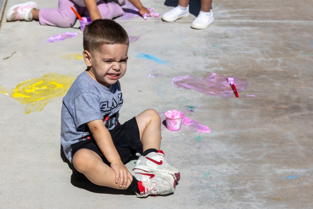Young child reacts during outdoor painting activity for Earth Day event aboard MCLB Barstow's CDC