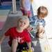 Children engage in outdoor painting activity for Earth Day event at the child development center