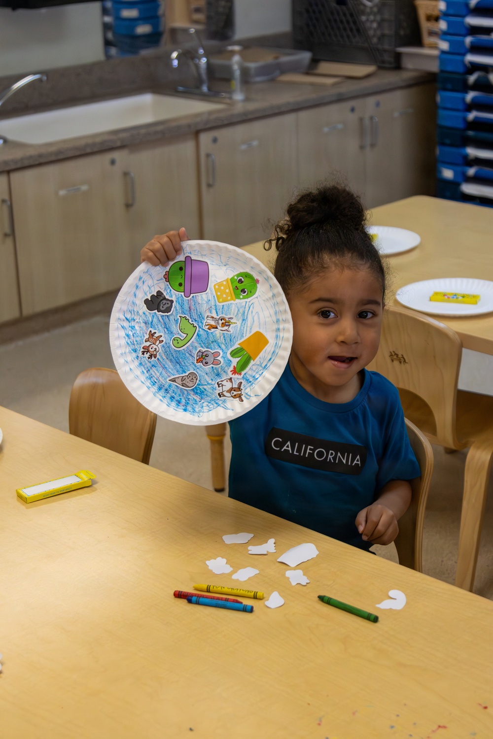 Child displays arts and crafts project at MCLB Barstow's Child Development Center