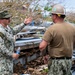 U.S. Sailors and U.S. Soldiers load lumber and ridge caps onto trucks