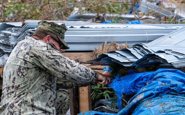 U.S. Sailors and U.S. Soldiers load lumber and ridge caps onto trucks