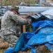 U.S. Sailors and U.S. Soldiers load lumber and ridge caps onto trucks