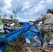 U.S. Sailors and U.S. Soldiers load lumber and ridge caps onto trucks