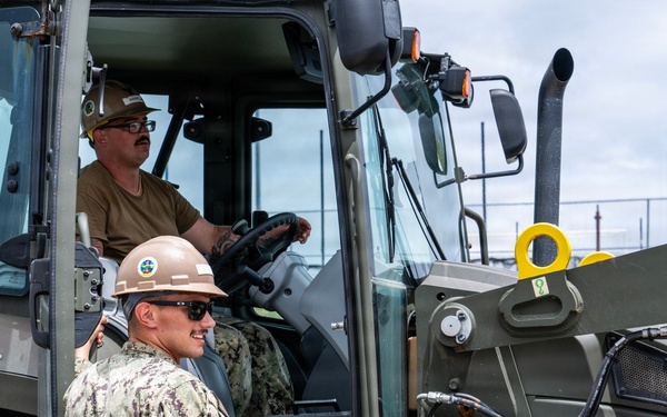 U.S. Sailors and U.S. Soldiers load lumber and ridge caps onto trucks
