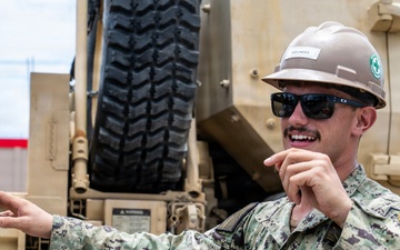 U.S. Sailors and U.S. Soldiers load lumber and ridge caps onto trucks