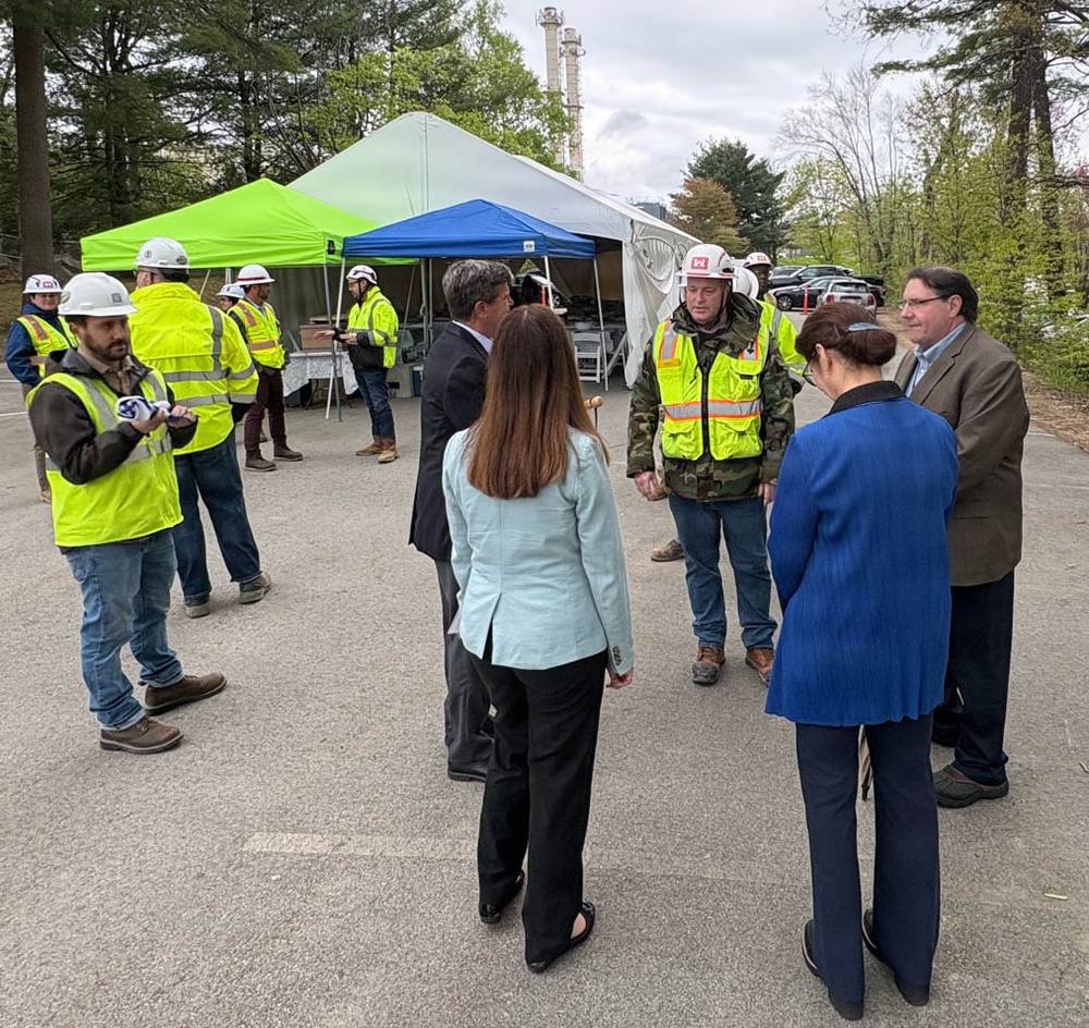 Officials and construction personnel gather at Topping Out Ceremony