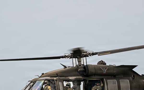 U.S. Army UH-60 Black Hawk helicopter crew conducts airborne operations over wooded terrain