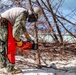 NMCB 1 Sailors clear an area with chainsaws and a backhoe