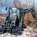 NMCB 1 Sailors clear an area with chainsaws and a backhoe