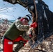 NMCB 1 Sailors clear an area with chainsaws and a backhoe