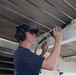 USCGC Eagle crew members and cadets prep the training barque for paint ahead of America 250 events