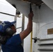 USCGC Eagle crew members and cadets prep the training barque for paint ahead of America 250 events