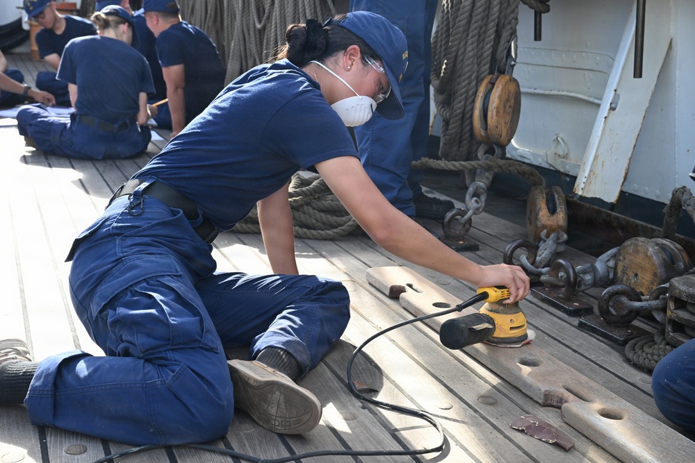 USCGC Eagle crew members and cadets prep the training barque for paint ahead of America 250 events