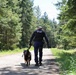Police K-9 Unit Handler Patrols Forest Road with Military Working Dog