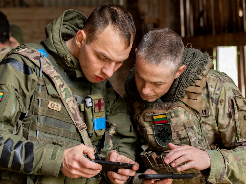 Army National Guard Soldier coordinates with Lithuanian Armed Forces Member