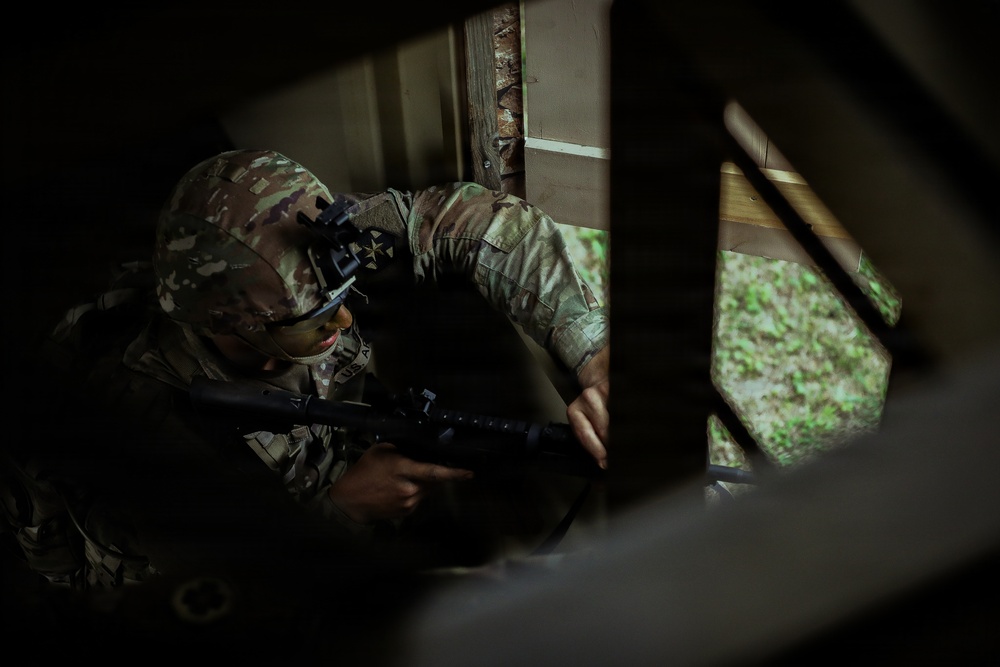 U.S. Army Reserve Soldier Provides Security for his Squad in a Seized Enemy Building during the Best Squad Competition