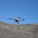 Quadcopter UAS conducts flight operations over arid desert terrain