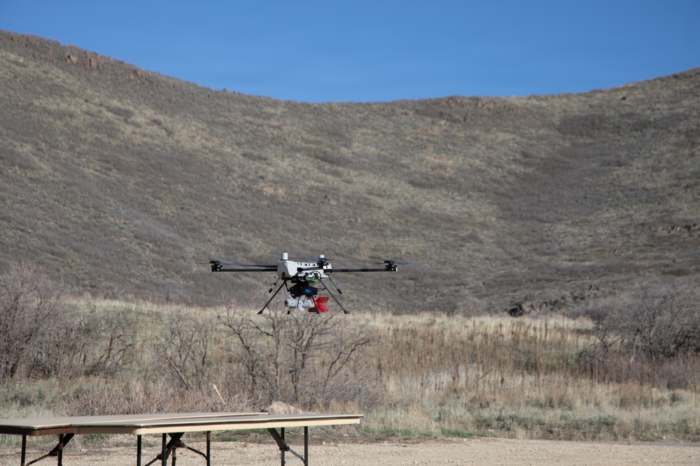 Quadcopter drone hovers during outdoor field test in arid terrain