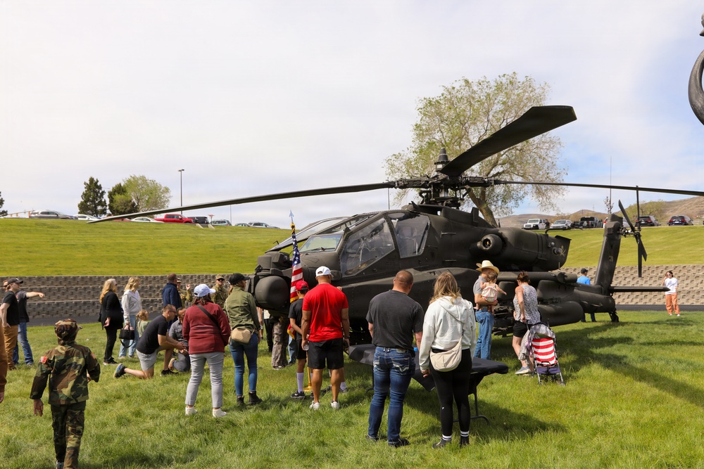 Community members gather around U.S. Army AH-64 Apache attack helicopter during public static display event