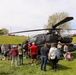 Community members gather around U.S. Army AH-64 Apache attack helicopter during public static display event