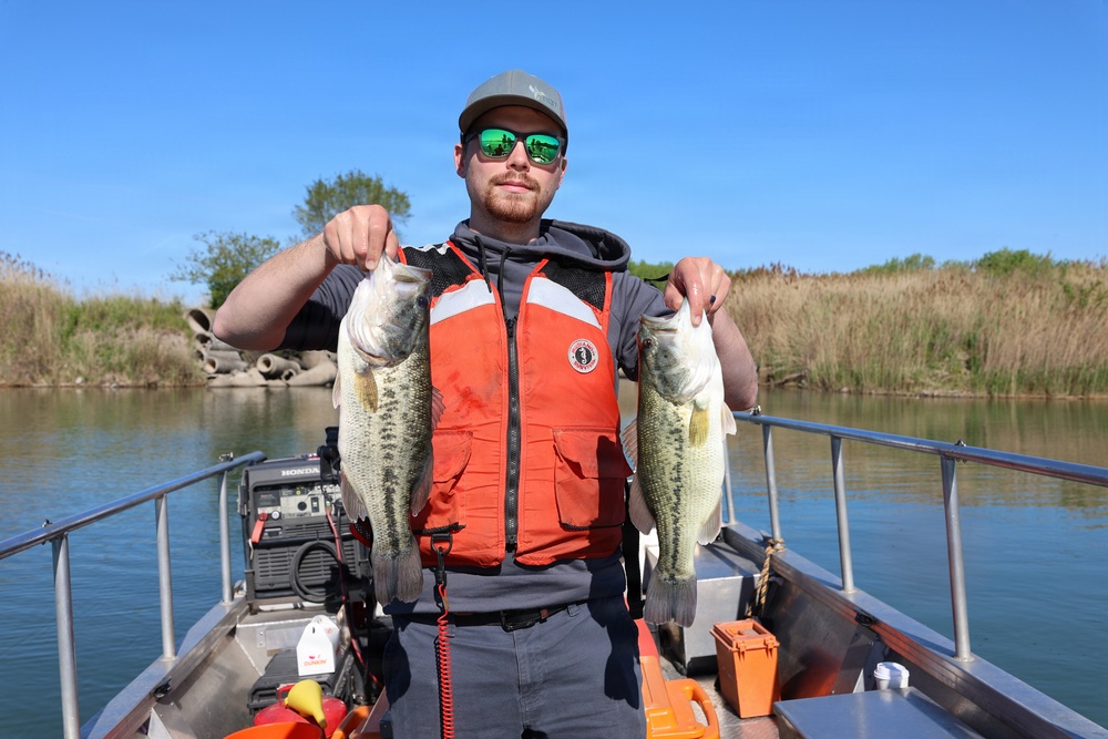 Crew member holding two largemouth bass