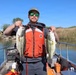 Crew member holding two largemouth bass