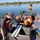 Three-person crew prepping on aluminum survey boat Three-person crew prepping on aluminum survey boat