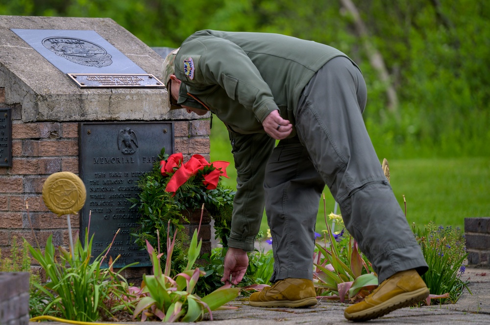 Skinner Places Flower at Memorial Ceremony