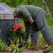 Skinner Places Flower at Memorial Ceremony