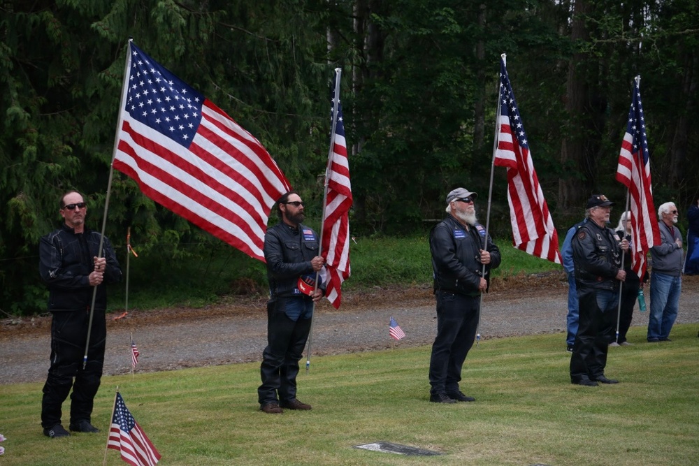 Motorcycle club members form flag line at veterans cemetery memorial service
