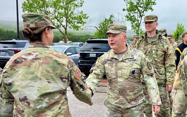 Fellow officer congratulates outgoing officer during farewell ceremony at West Fort Hood