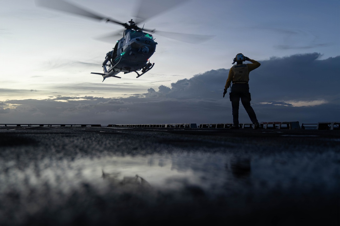 A U.S. Sailor assigned to the San Antonio-class amphibious transport dock USS Fort Lauderdale (LPD 28) gives a send-off salute as a U.S. Marine Corps UH-1Y Venom  assigned to Marine Medium Tiltrotor Squadron (VMM) 365 (Reinforced), Littoral Combat Force-24, takes off during night deck landing qualifications while underway in the Caribbean Sea, May 19, 2026. U.S. military forces are deployed to the U.S. Southern Command area of responsibility in support of Operation SOUTHERN SPEAR, Department of War-directed operations, and the president’s priorities to disrupt illicit drug trafficking, deter malign actors and protect the homeland through continuous presence. (U.S. Marine Corps photo)