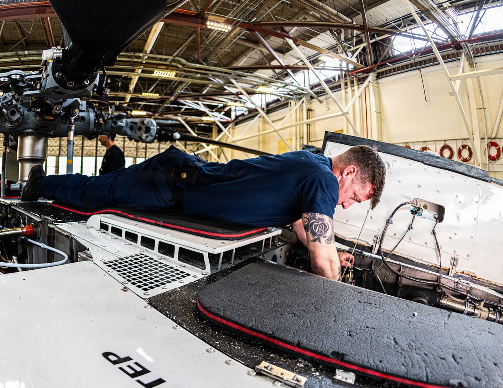 Coast Guard aircraft maintainers conduct maintenance on helicopter in Kodiak, Alaska