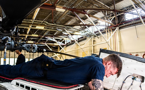 Coast Guard aircraft maintainers conduct maintenance on helicopter in Kodiak, Alaska