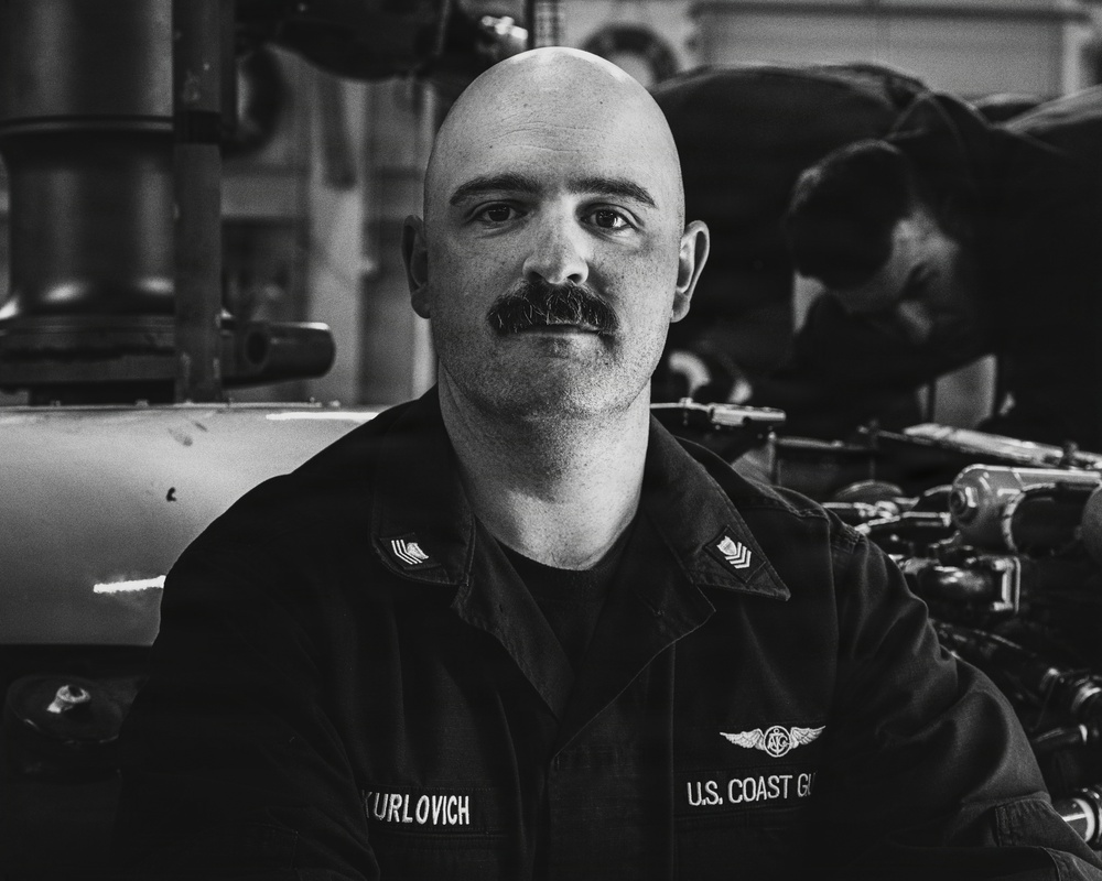 Coast Guard Air Station Kodiak maintainers sit for portraits during maintenance operations