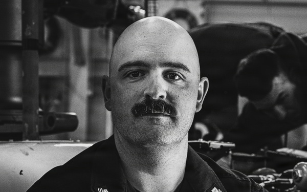 Coast Guard Air Station Kodiak maintainers sit for portraits during maintenance operations