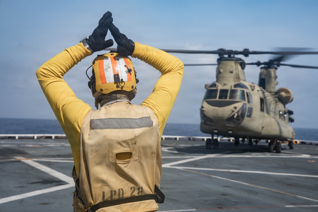 A U.S. Sailor with San Antonio-class amphibious transport dock USS Fort Lauderdale (LPD 28) signals to a U.S. Army CH-47 Chinook assigned to Joint Task Force-Bravo, during deck landing qualifications while underway in the Caribbean Sea, June 4, 2026. U.S. military forces are deployed to the U.S. Southern Command area of responsibility in support of Operation SOUTHERN SPEAR, Department of War-directed operations, and the president’s priorities to disrupt illicit drug trafficking, deter malign actors and protect the homeland through continuous presence. (U.S. Marine Corps photo)
