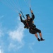 U.S. Army Golden Knights parachutist descends under black and gold canopy during Hyundai Air and Sea Show.