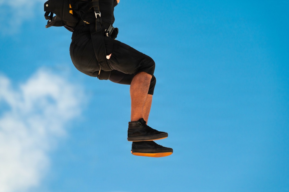 U.S. Army Golden Knights parachutist descends under black and gold canopy during Hyundai Air and Sea Show