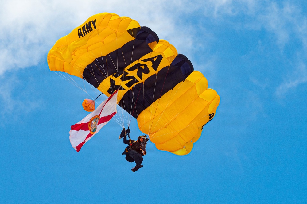 U.S. Army Golden Knights parachutist carries Florida state flag during aerial demonstration at Miami Beach