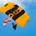 U.S. Army Golden Knights parachutist carries Florida state flag during aerial demonstration at Miami Beach