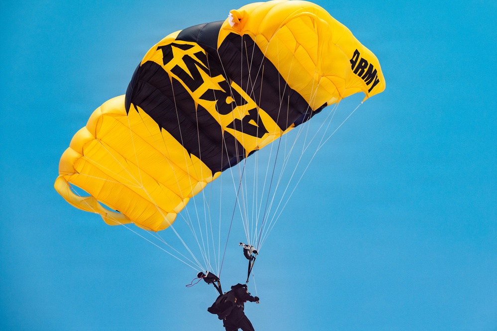 U.S. Army Golden Knights parachutist descends under black and gold canopy during Hyundai Air and Sea Show