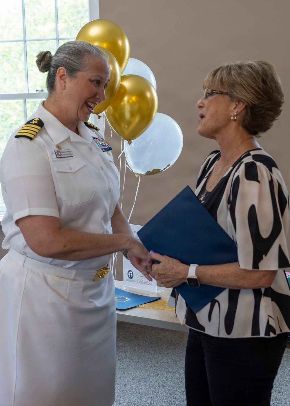 Capt. Chandra "Mamasan" Newman, Naval Air Station (NAS) Pensacola's commanding officer, presents a letter of appreciation to Navy-Marine Corps Relief Society (NMCRS) Relief Services Assistant Amanda Shadden recognizing her 20 years of service, June 5.