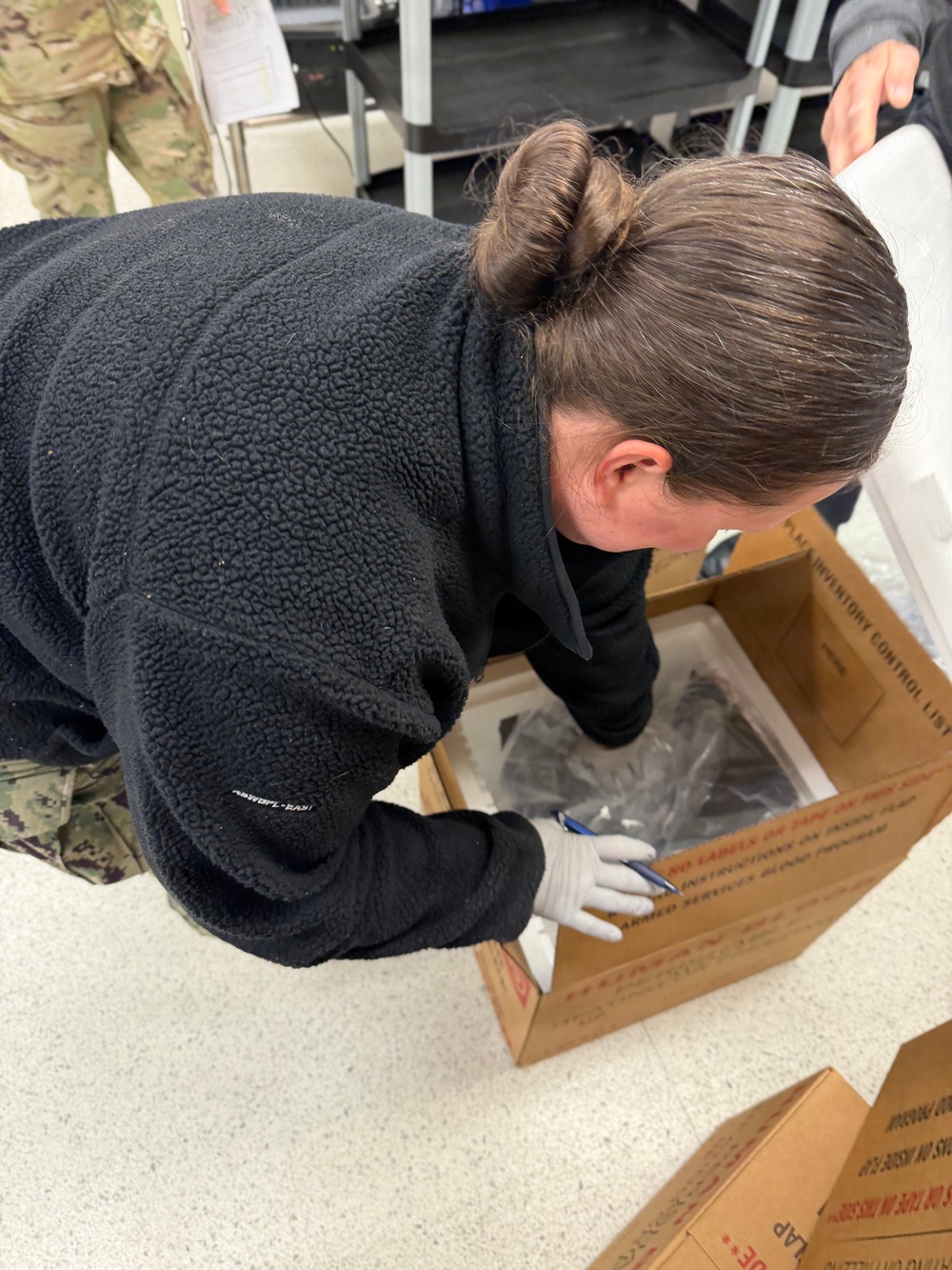U.S. Navy Hospital Corpsman First Class Kristen Gordon prepares a temperature-controlled shipping container for blood products at the Armed Services Whole Blood Processing Laboratory-East