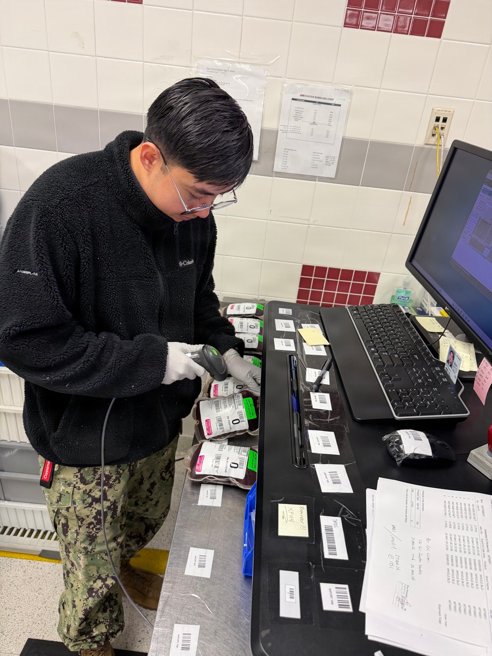 U.S. Navy Hospital Corpsman First Class Gian Molina scans units of blood into an inventory tracking system at the Armed Services Whole Blood Processing Laboratory-East.